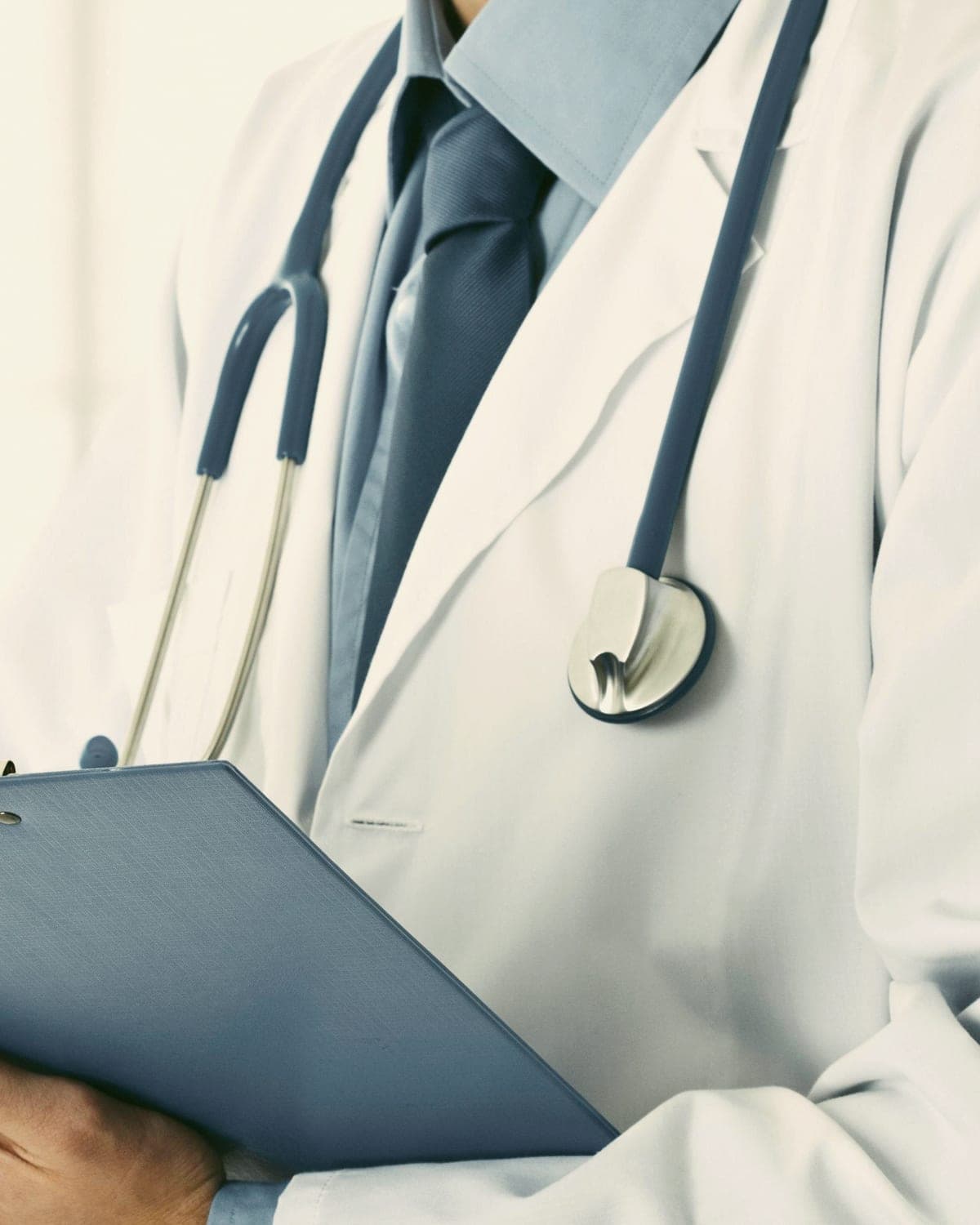 A family physician in a white coat with a stethoscope and clipboard