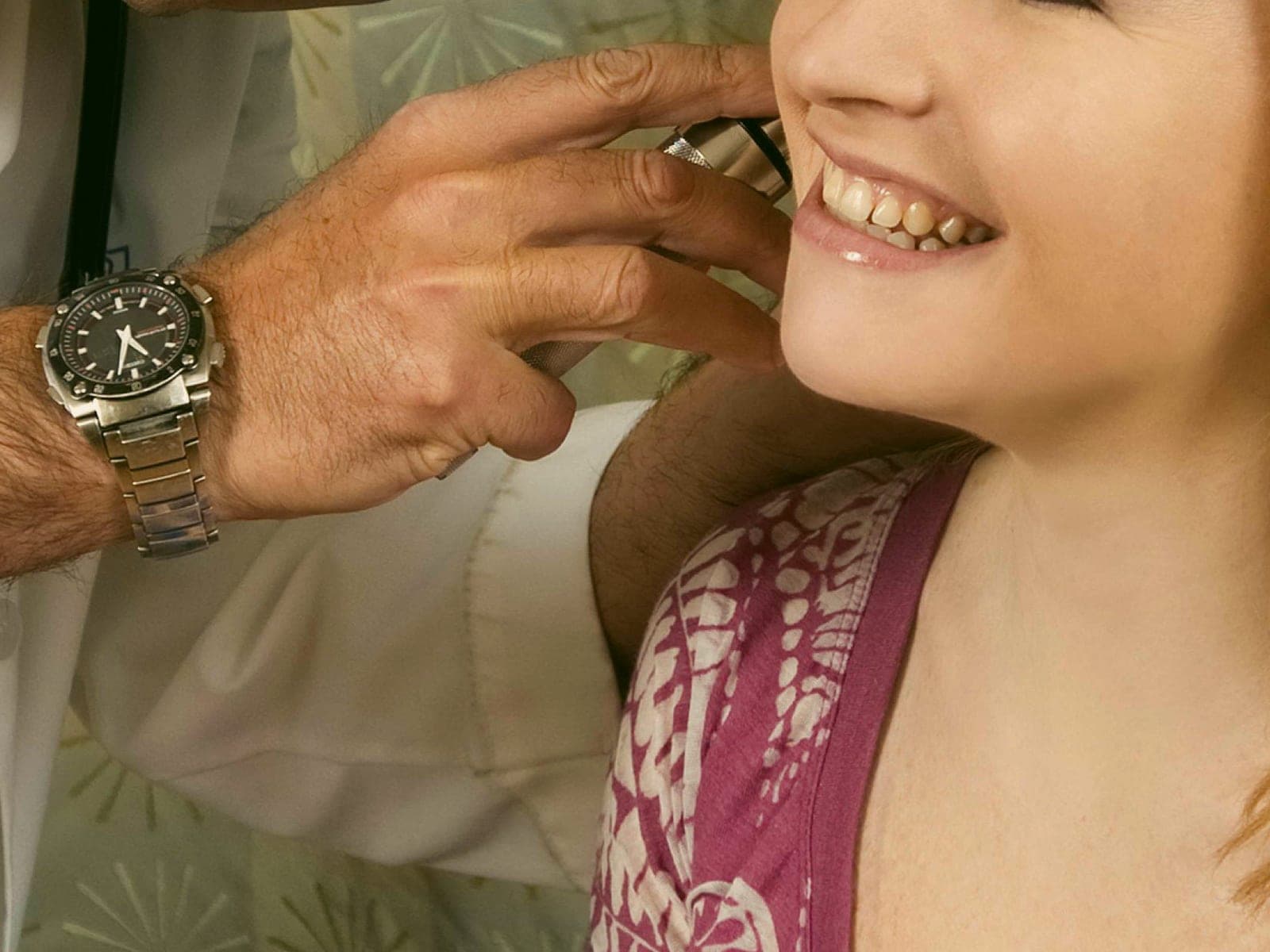 A doctor checking a patient's ear during a sick visit
