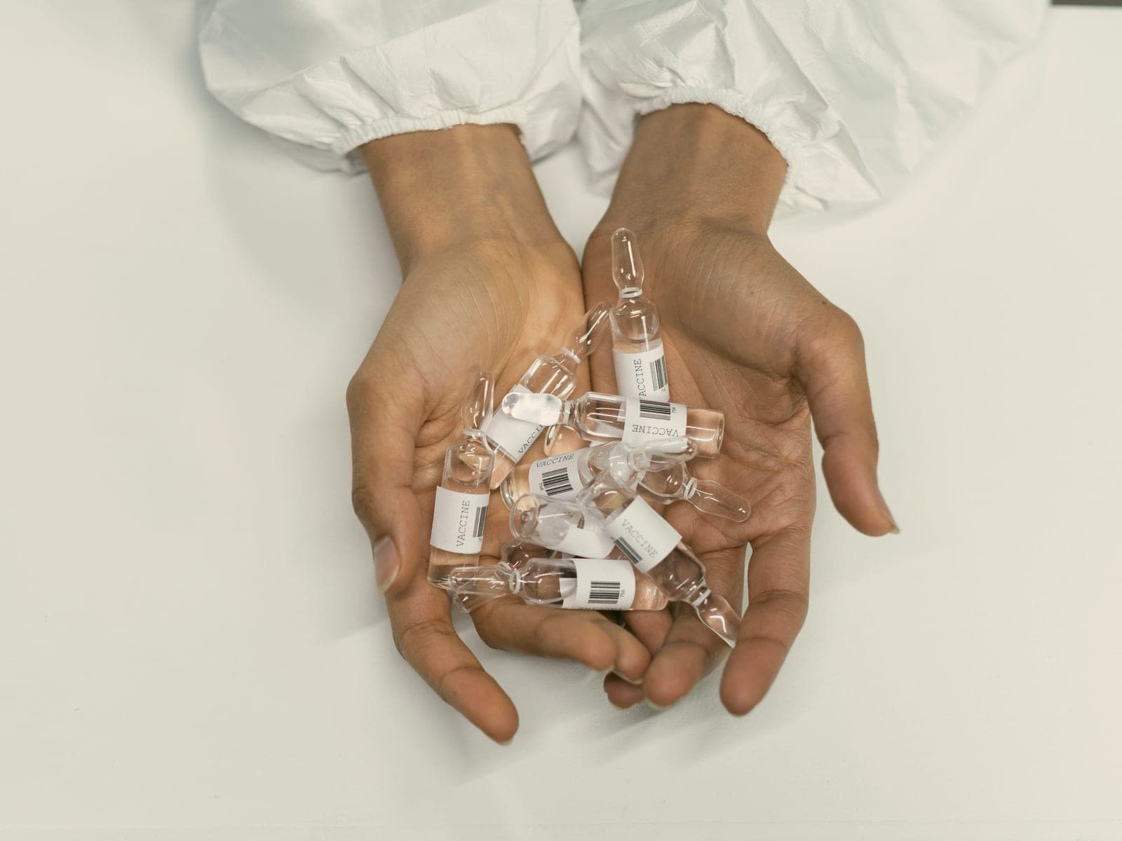 Cupped hands holding small vaccine vials